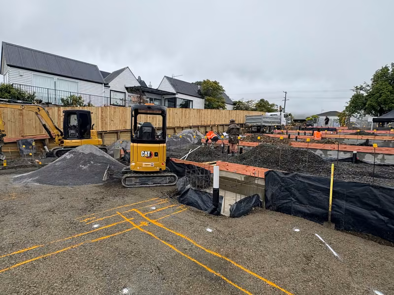 Compact excavator carrying out detailed excavation on a prepared site