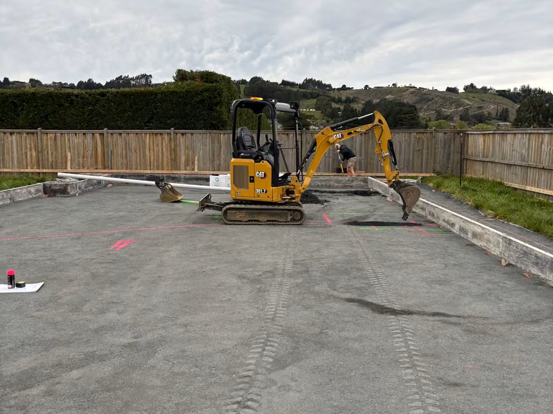 Compact excavator carrying out detailed work on a prepared site