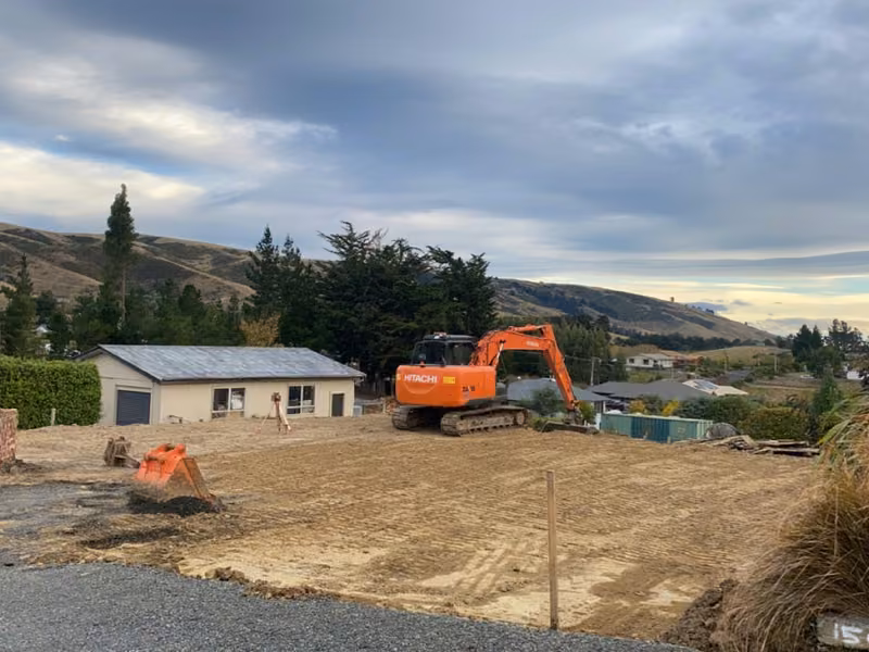 Excavator shaping and preparing a residential building site