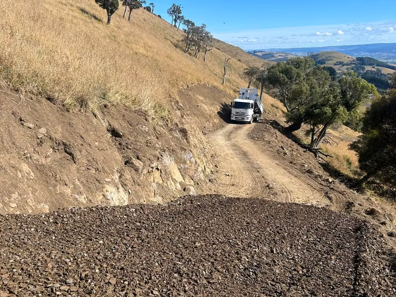 Newly formed access track traversing steep hill country
