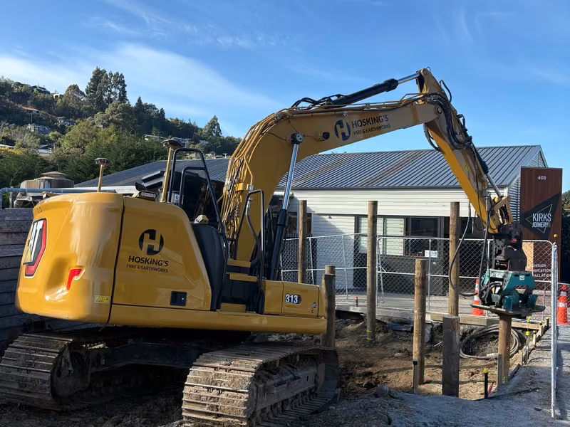 Excavator carrying out earthworks around a building site