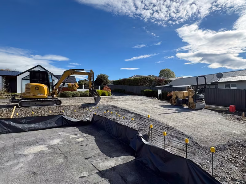Excavator carrying out detailed earthworks on a developed site