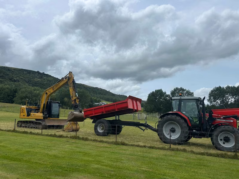 Excavator and tractor working together on a rural property