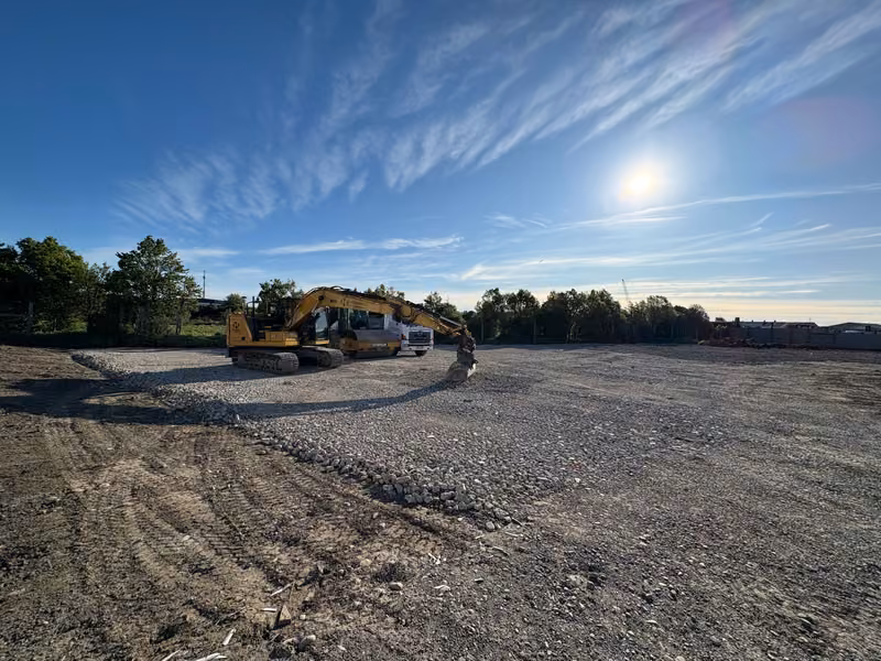 Excavators carrying out bulk site preparation across a large formed area